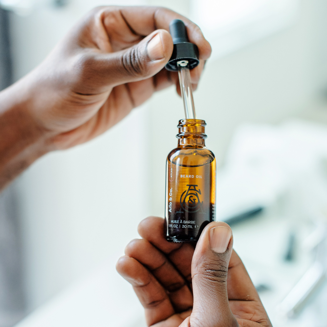 Beard oil bottle with black dropper, amber liquid, Atlas label