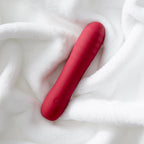 Berry-pink slim silicone wand vibrator on white plush fabric