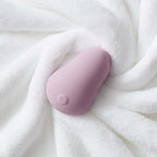 Light pink teardrop silicone personal massager with smooth domed tip on fabric