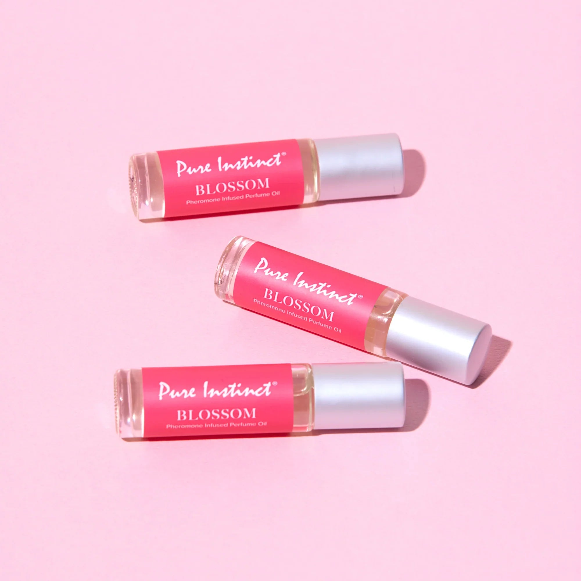 Set of Pink Blossom pheromone roll-ons with silver caps and red labels