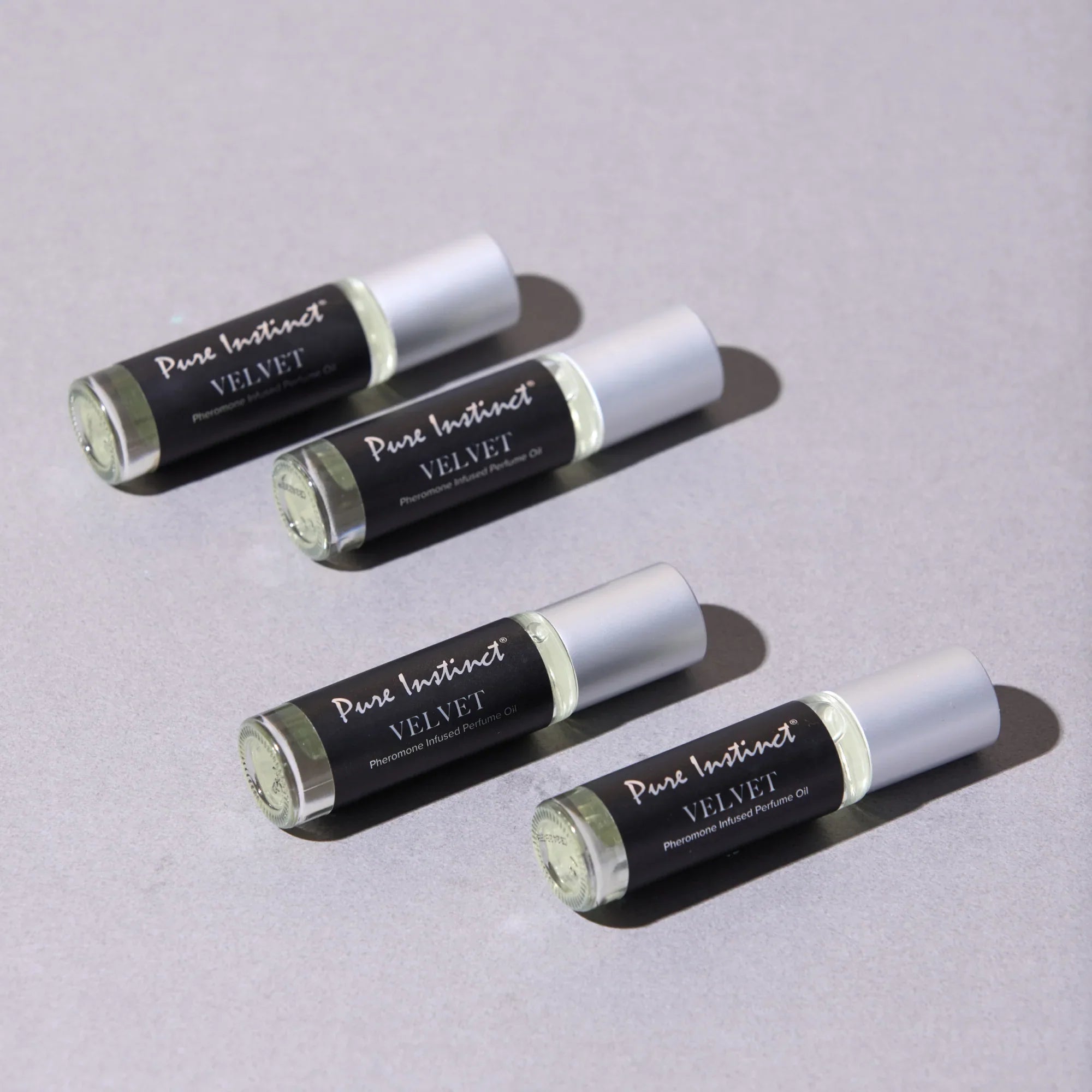 Set of velvet pheromone roll-on bottles with silver caps and black labels