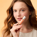 Woman holding a pheromone roll-on perfume bottle with silver cap
