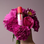 Basic Instinct sex attractant bottle with red cap, shown with bouquet flowers