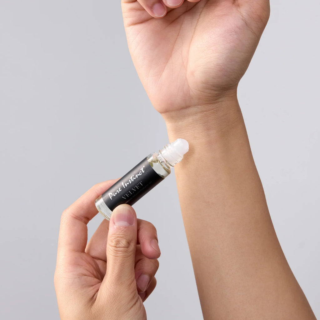 Hands holding velvet pheromone roll-on with white roller applicator
