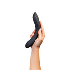 Curved black G-spot vibrator held in hand, angled profile