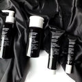 Uncovered Skincare Daily Essentials Kit tubes and bottles on dark cloth
