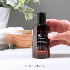 HeLi massage oil bottle held in hand, dark cap, amber label with Hello Libido