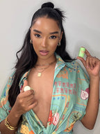 Green roll-on fragrance stick held in hand near a person wearing jewelry