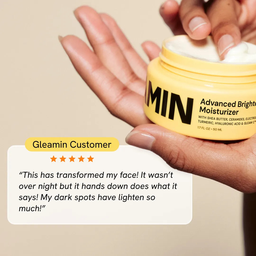 Brightening moisturizer jar held in an open palm, yellow container close-up