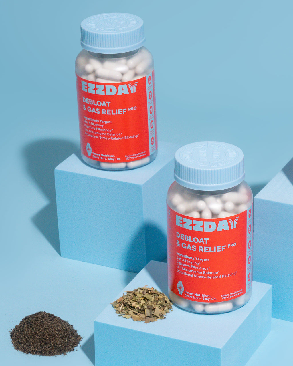 Supplement bottles with blue caps and red labels, with scattered capsules and herbs
