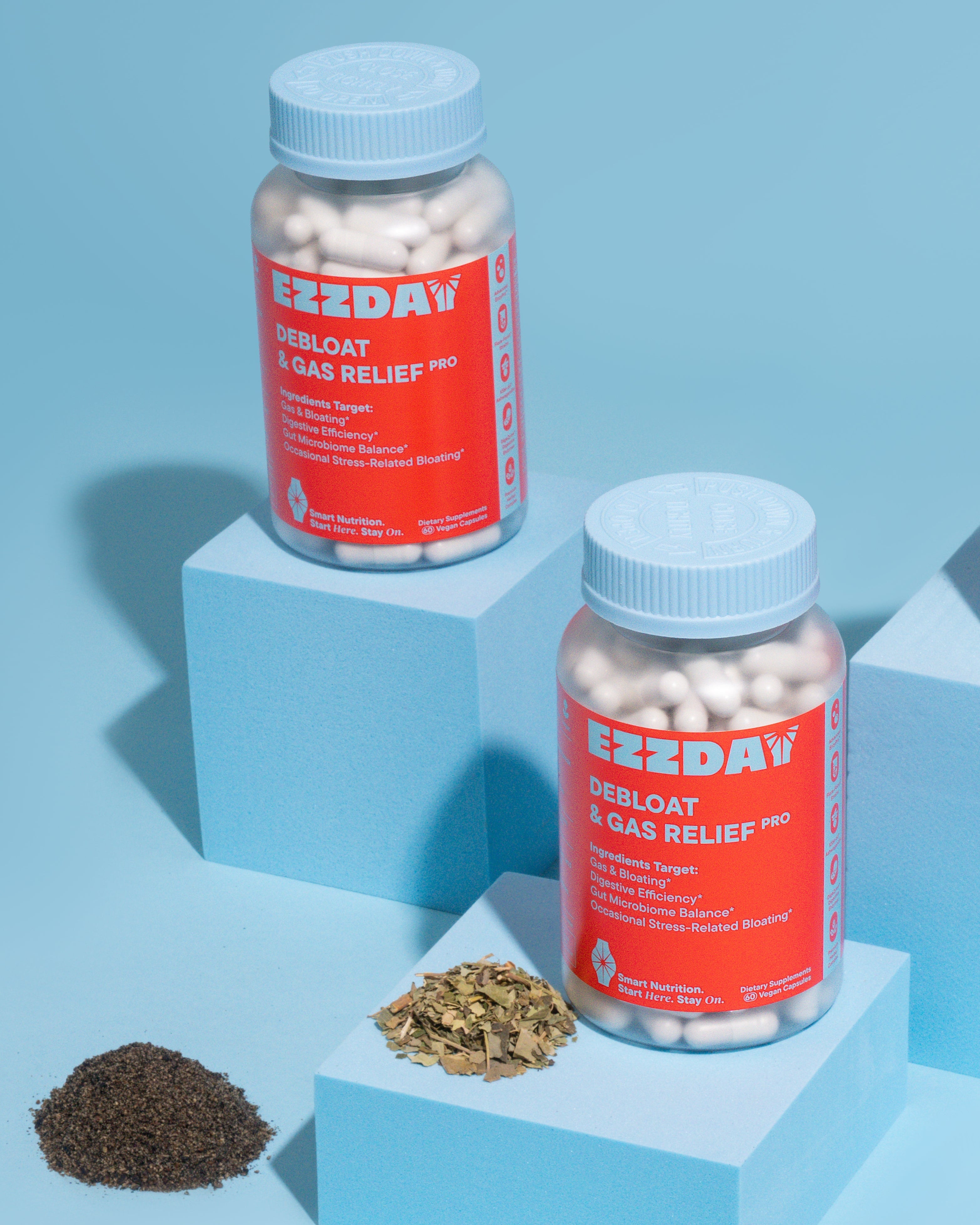 Supplement bottles with blue caps and red labels, with scattered capsules and herbs