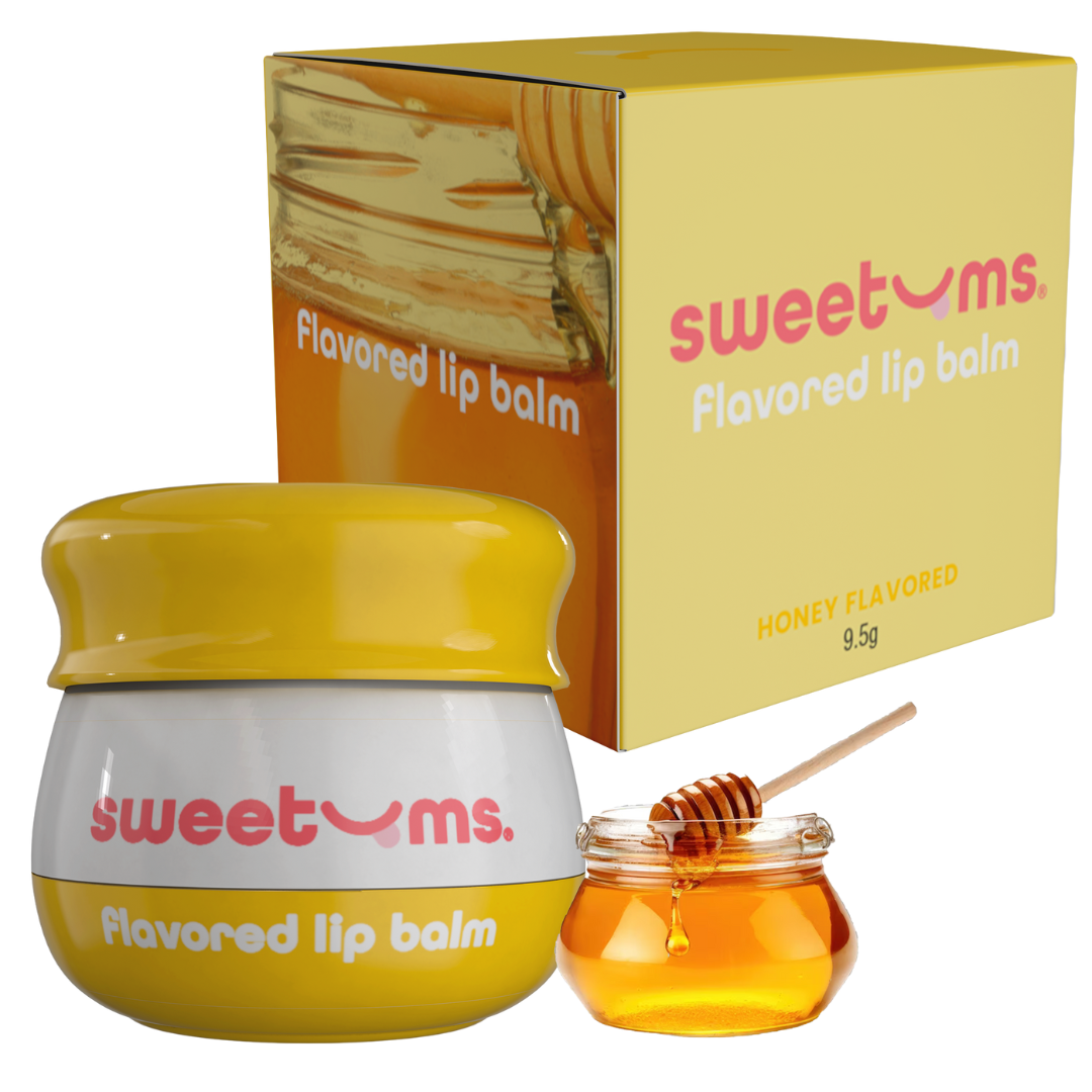 Honey flavored lip balm jar with yellow cap and honey dipper beside lip balm box