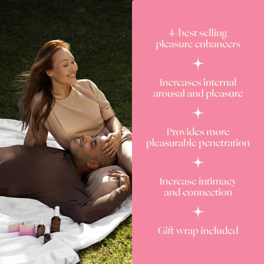 Intimacy set with amber oil bottles and pink packaging beside a relaxing couple