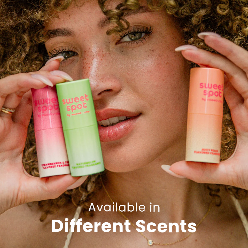 Small roll-on fragrance tubes in pink, green, and peach held near face