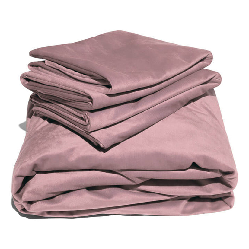 Pink liquid velvet sheet and pillowcases set, folded layers with shiny velvet finish.