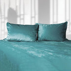 Teal liquid velvet sheet and two matching pillowcases, made bed set with shimmering finish.