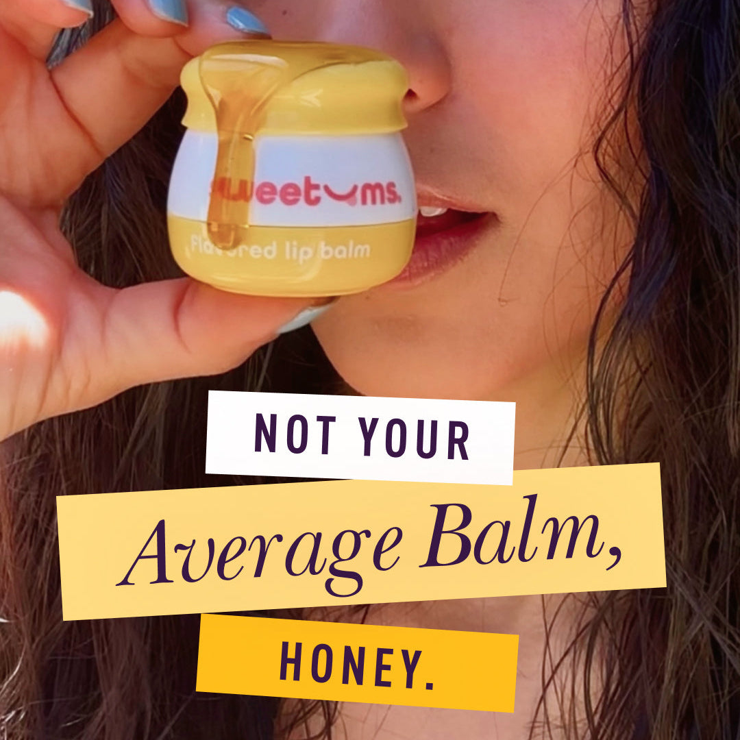 Honey flavored lip balm jar held near lips with yellow cap