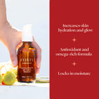 Body oil bottle with white pump and amber liquid, near yellow flower