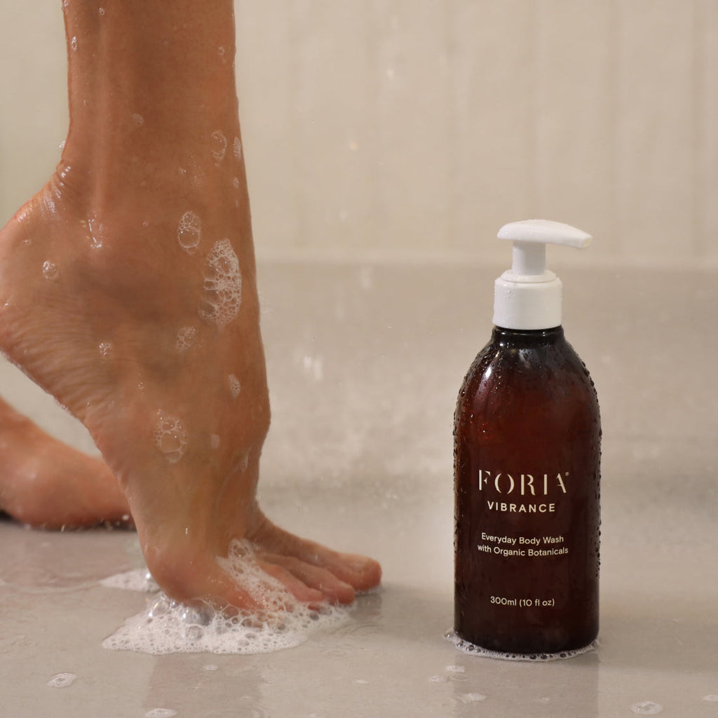 Body wash pump bottle with amber liquid and foaming cleanser on legs