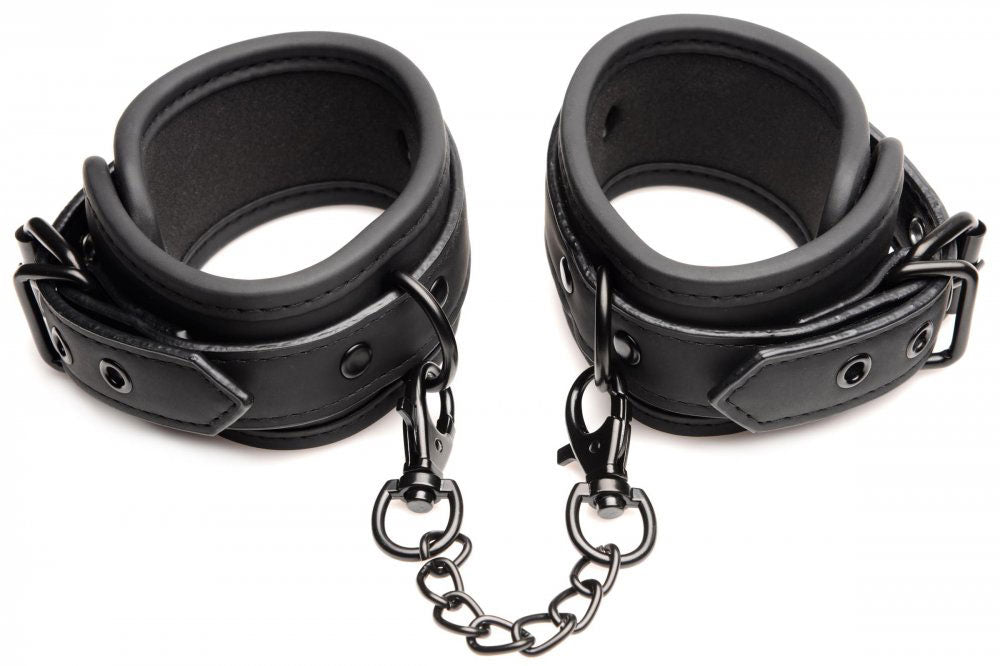 Black leather-like wrist cuffs with metal rings and short chain links
