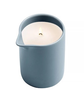 Scented candle in blue ceramic jar with cream wax and visible wick