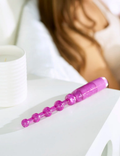 Purple glitter beaded wand, lying on a white surface