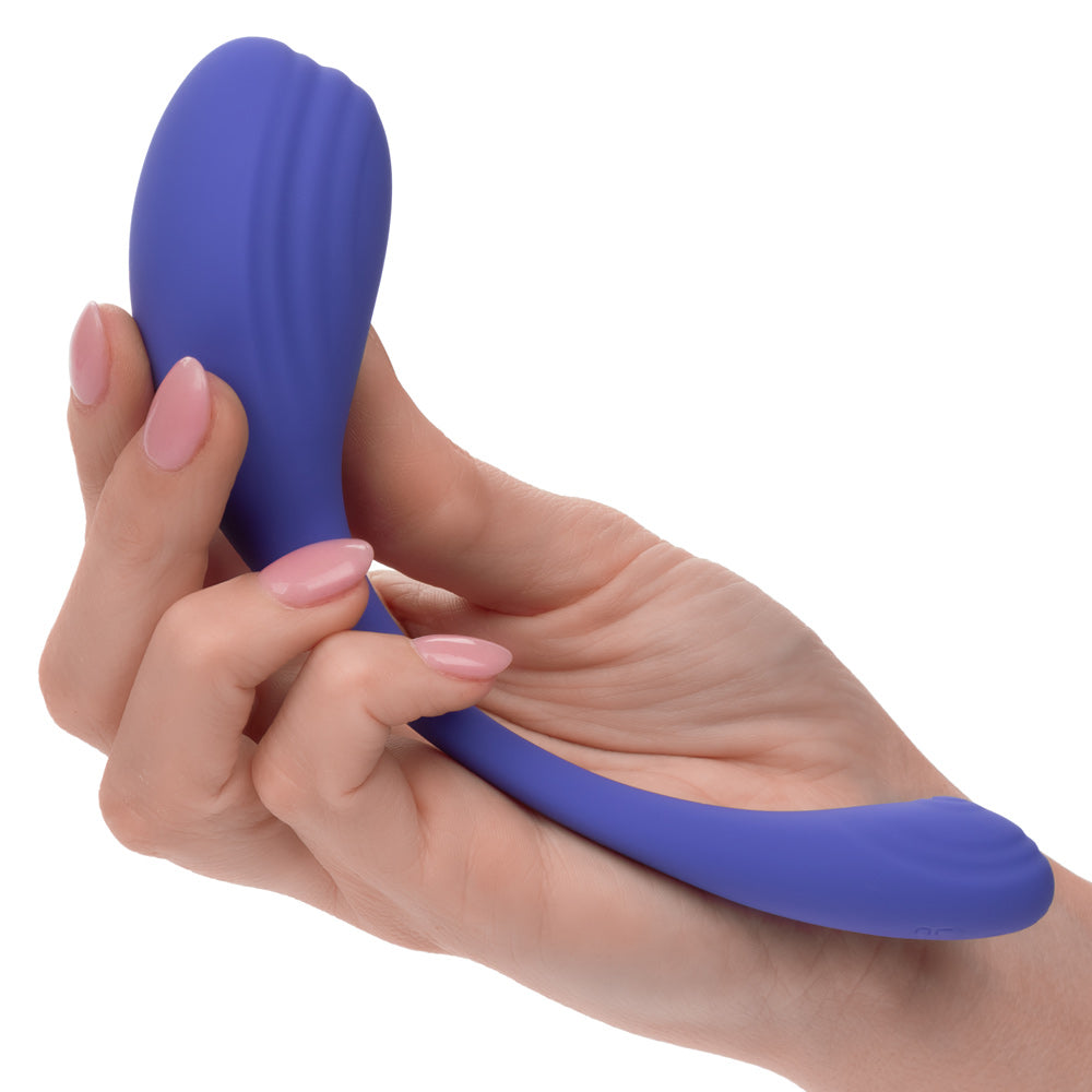 Periwinkle curved kegel exerciser with ridged surface in hand