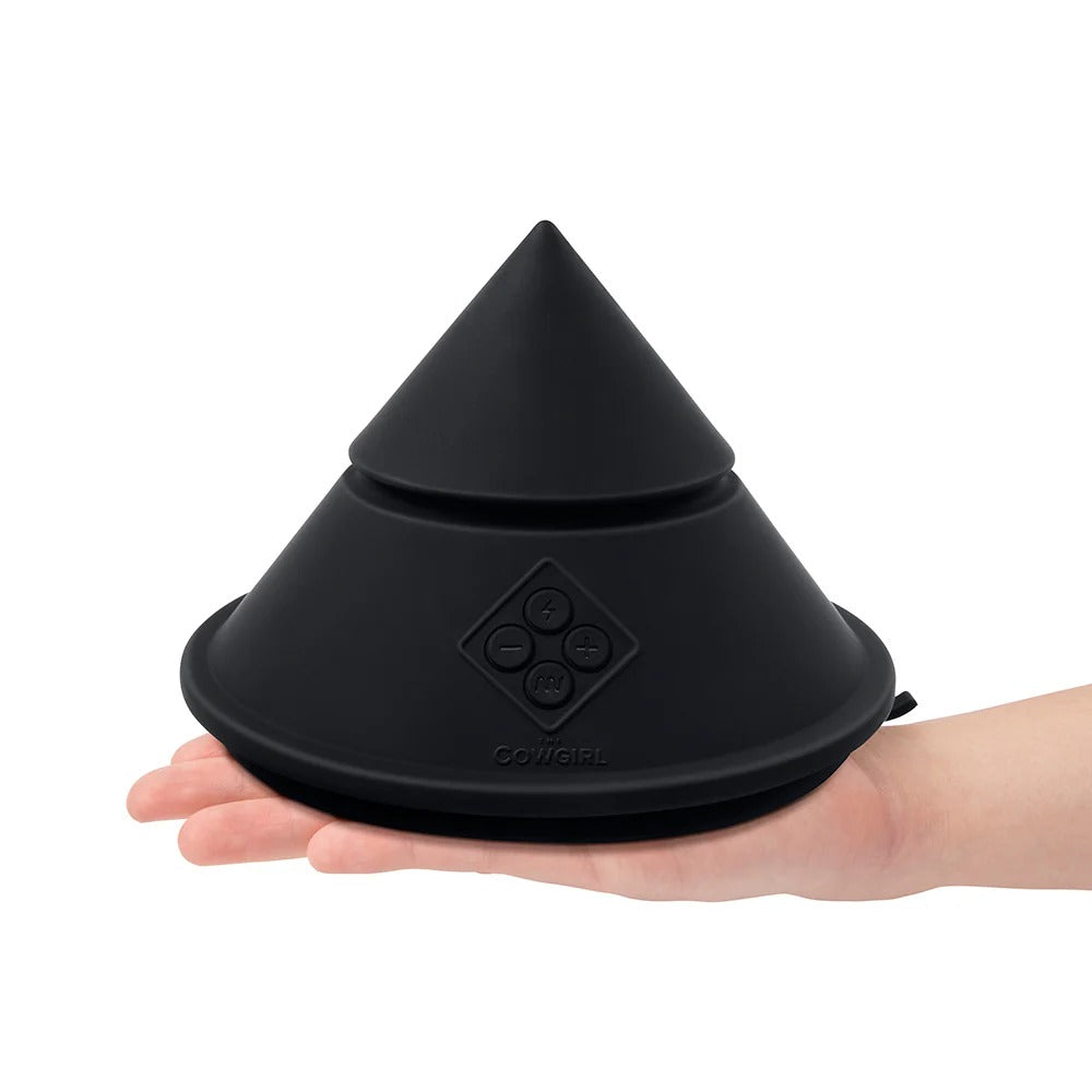 Black cone-shaped sex massager in an open palm, cone top and base shown