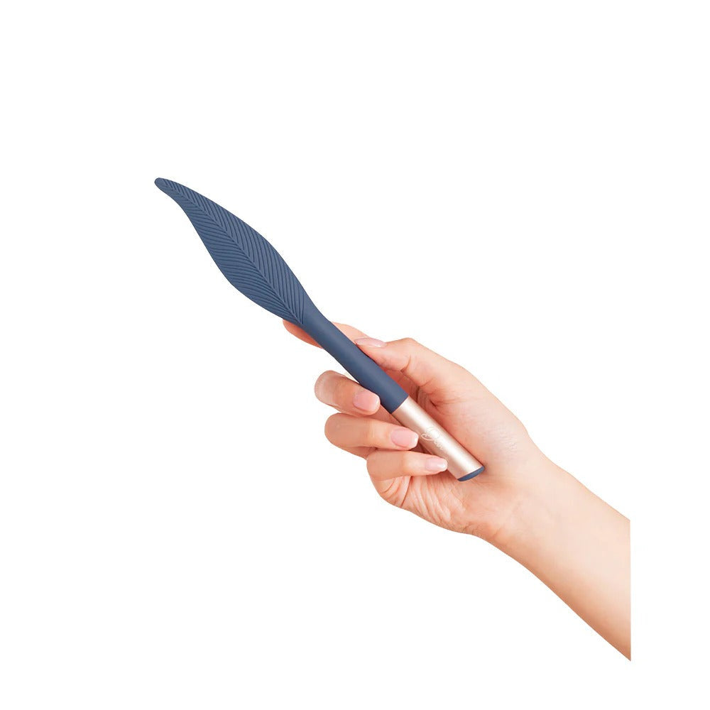 Vibrating feather tickler held in hand, navy feather head and metallic pink handle
