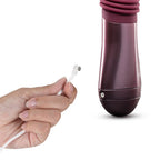 Pink thrusting vibe with dark base while charging cable is inserted.