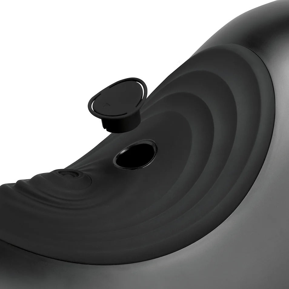 Black saddle massager close-up with circular control and side port