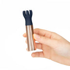 Mini massager with navy silicone prongs on a clear ridged cylinder, held in hand