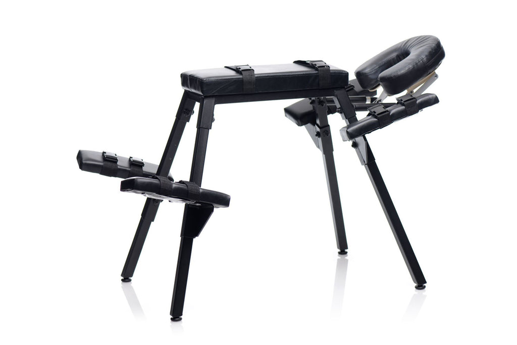 Black padded sex bench with arm and leg restraint pads on four legs