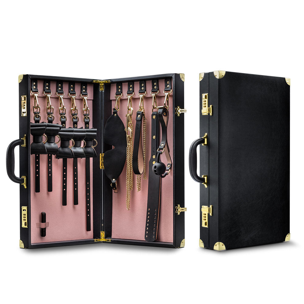 Bondage kit suitcase open with pink lining and multiple black leather cuffs and straps