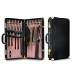 Bondage kit suitcase open with pink lining and multiple black leather cuffs and straps